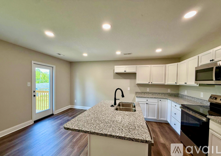 A kitchen with a granite countertop and white cabinets.