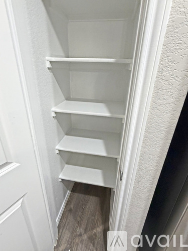 Empty white shelves in a pantry.
