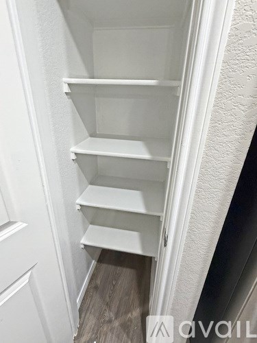 Empty white shelves in a pantry.