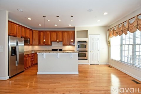 A kitchen with wooden cabinets and a white island.