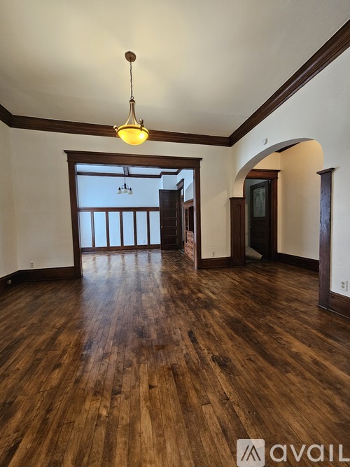 A room with wooden floors and a hanging light fixture.