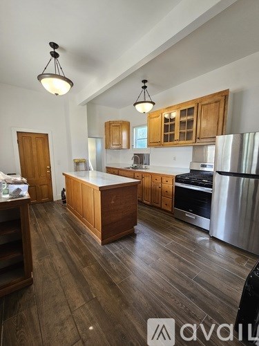 A kitchen with wooden cabinets and a wooden island.