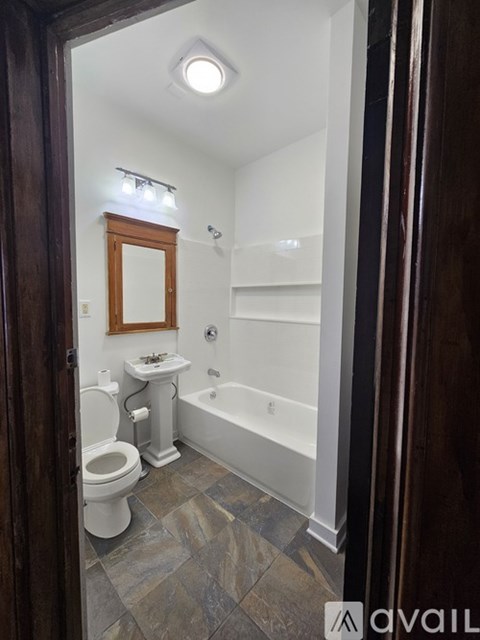 A bathroom with a toilet, sink, and bathtub.