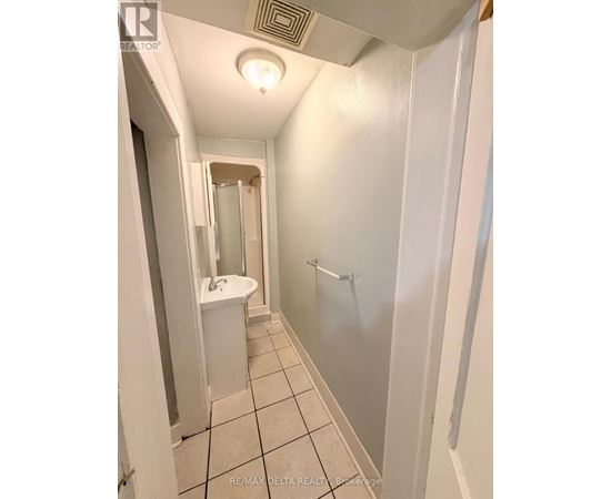 A white bathroom with a sink, mirror, and shower.