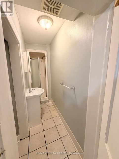 A white bathroom with a sink, mirror, and shower.