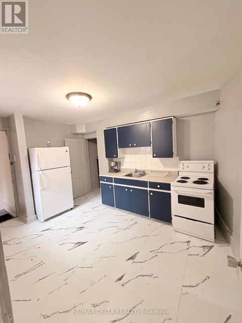 A kitchen with a white fridge, white stove, and blue cabinets.