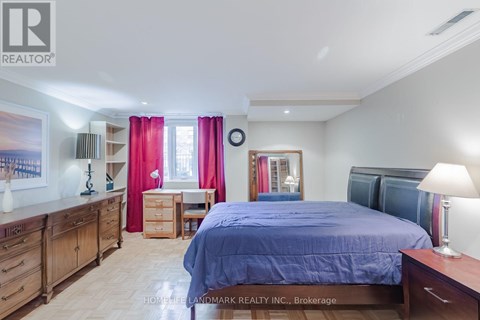 A bedroom with a bed, dresser, and desk.