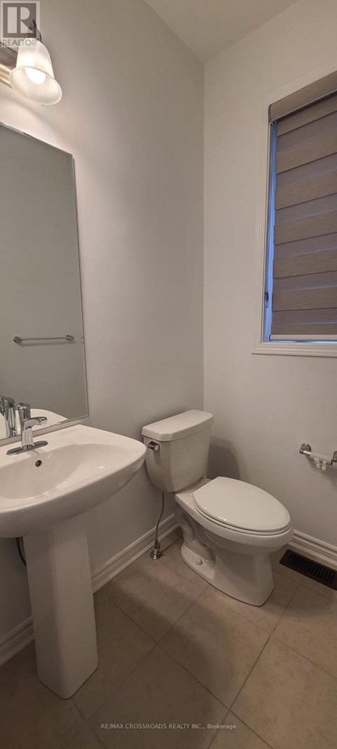 A white toilet is in a bathroom next to a sink.
