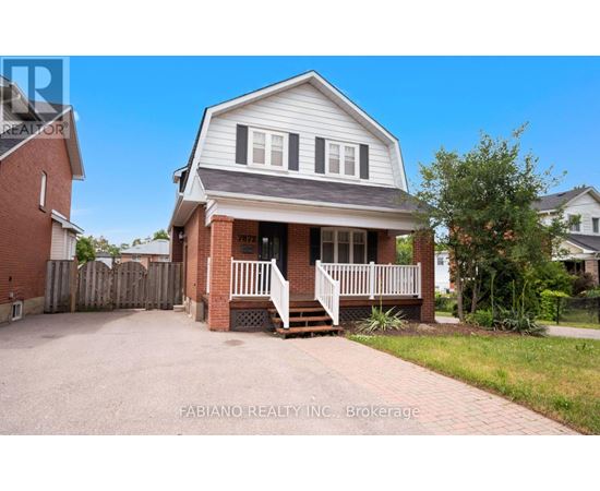 A house with a white front porch and a brick base is for sale.