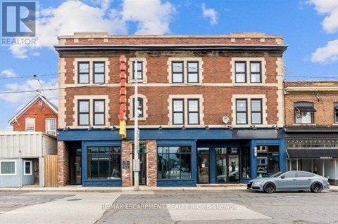 A building with a blue awning and a car parked in front.