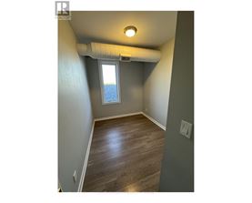 A room with a window and a wooden floor.