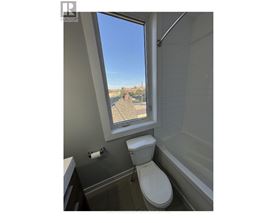 A bathroom with a toilet, a bathtub, and a window.