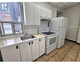 A kitchen with white appliances and cabinets.