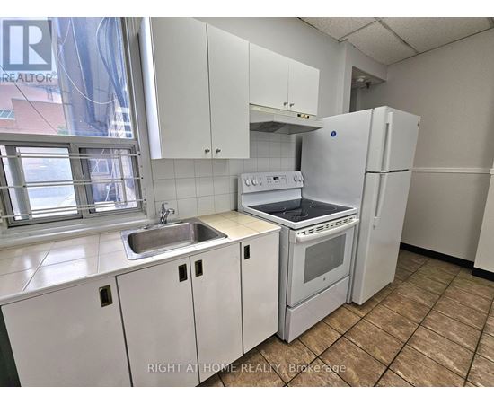 A kitchen with white appliances and cabinets.