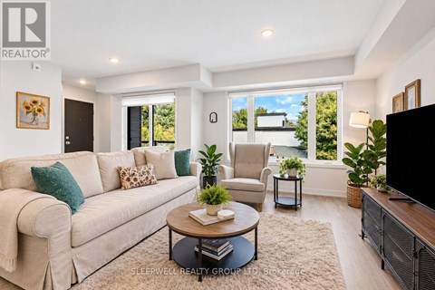 A living room with a beige couch, a coffee table, and a flat screen TV.