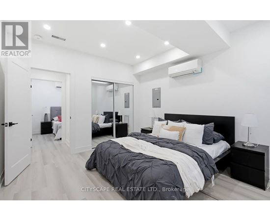 A bedroom with a large bed and a mirrored closet door.