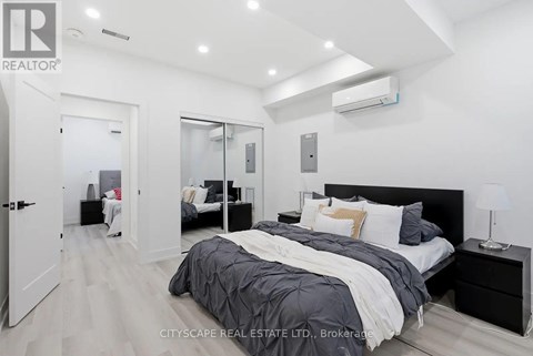 A bedroom with a large bed and a mirrored closet door.