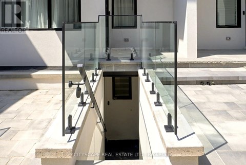 A glass staircase leads down to a small pool.