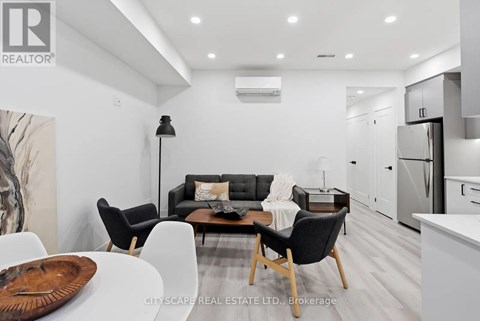 A modern living room with a black sofa and wooden coffee table.