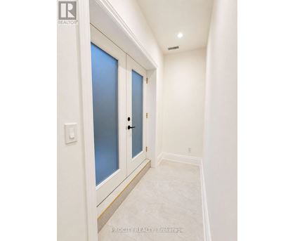 A hallway with a white door and a light switch.