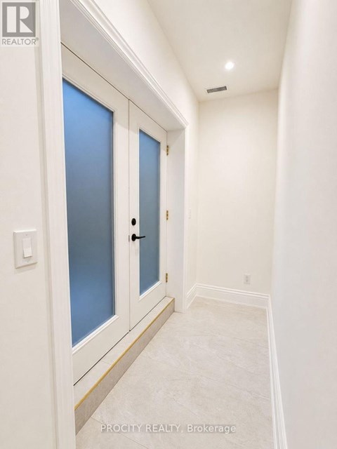 A hallway with a white door and a light switch.