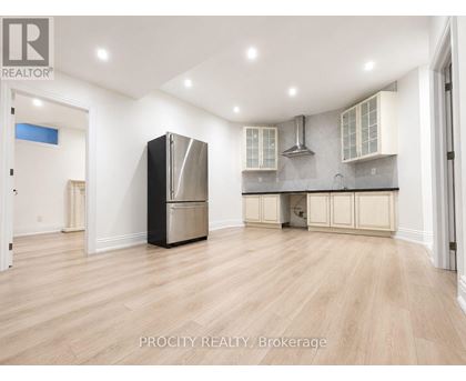 A kitchen with a refrigerator, stove, and cabinets.