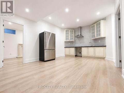 A kitchen with a refrigerator, stove, and cabinets.