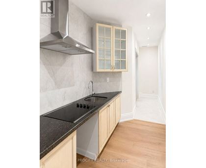 A kitchen with a stove top oven and a hood.