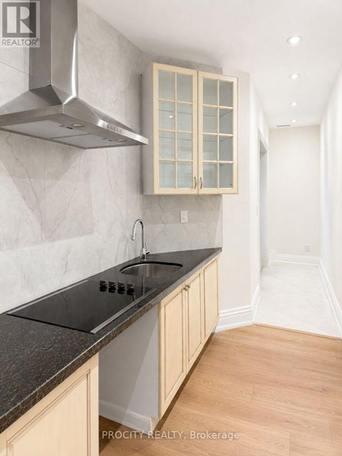 A kitchen with a stove top oven and a hood.