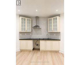 A kitchen with a black countertop and white cabinets.
