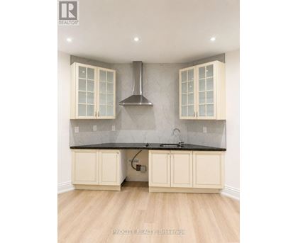 A kitchen with a black countertop and white cabinets.