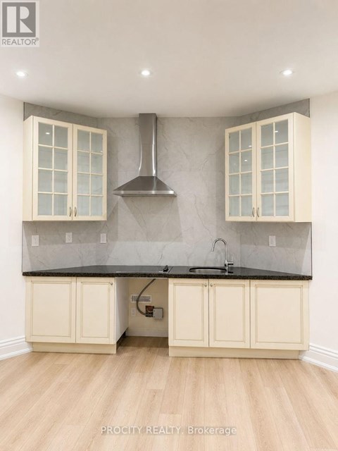 A kitchen with a black countertop and white cabinets.