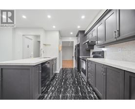 A kitchen with black cabinets and a marble counter top.