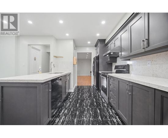 A kitchen with black cabinets and a marble counter top.