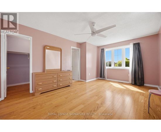 A bedroom with a dresser and a window with curtains.
