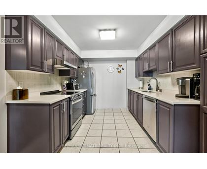 A kitchen with dark brown cabinets and a white counter top.
