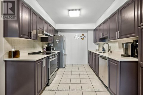 A kitchen with dark brown cabinets and a white counter top.
