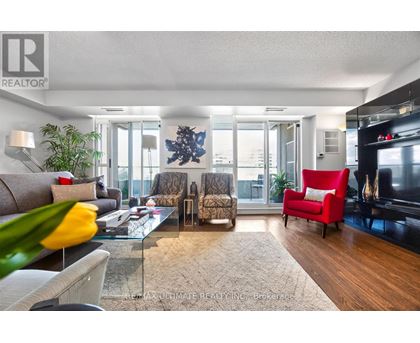 A living room with a glass table and a red chair.