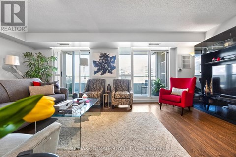 A living room with a glass table and a red chair.