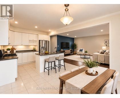 A well-lit kitchen and living room with a dining table set for two.