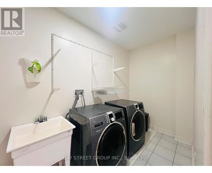 A laundry room with a white sink and two washing machines.