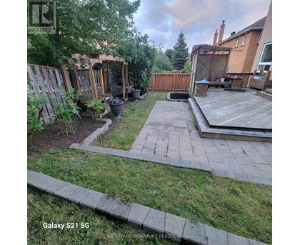 A backyard with a wooden deck and a small gazebo.