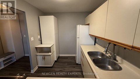 A kitchen with white cabinets and a sink.