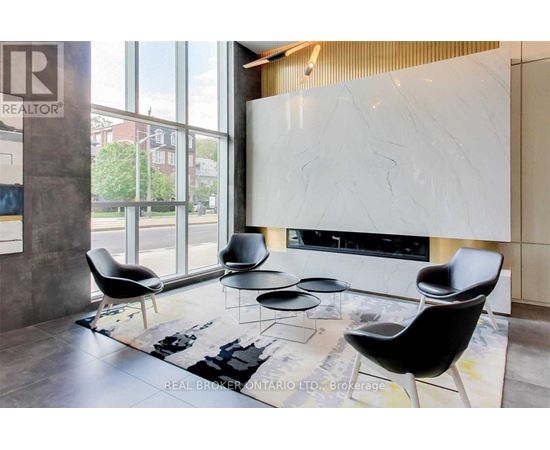 A living room with a white marble fireplace and black chairs.
