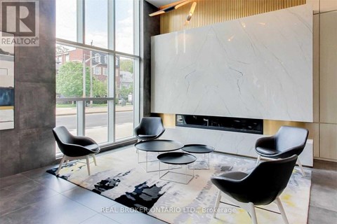 A living room with a white marble fireplace and black chairs.