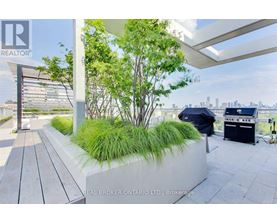 A patio area with a planter box and a grill.