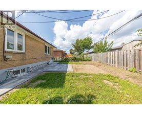 A backyard with a wooden fence and a grassy area.