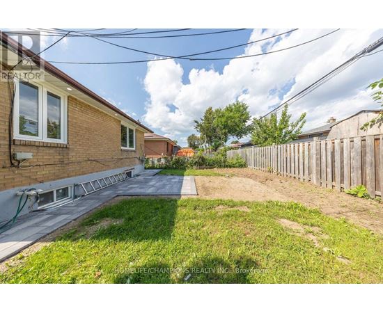 A backyard with a wooden fence and a grassy area.