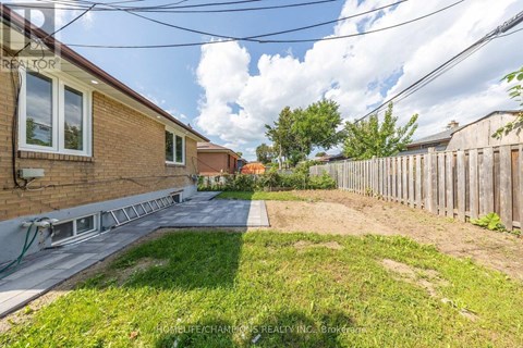 A backyard with a wooden fence and a grassy area.