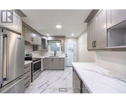 A modern kitchen with stainless steel appliances and marble countertops.